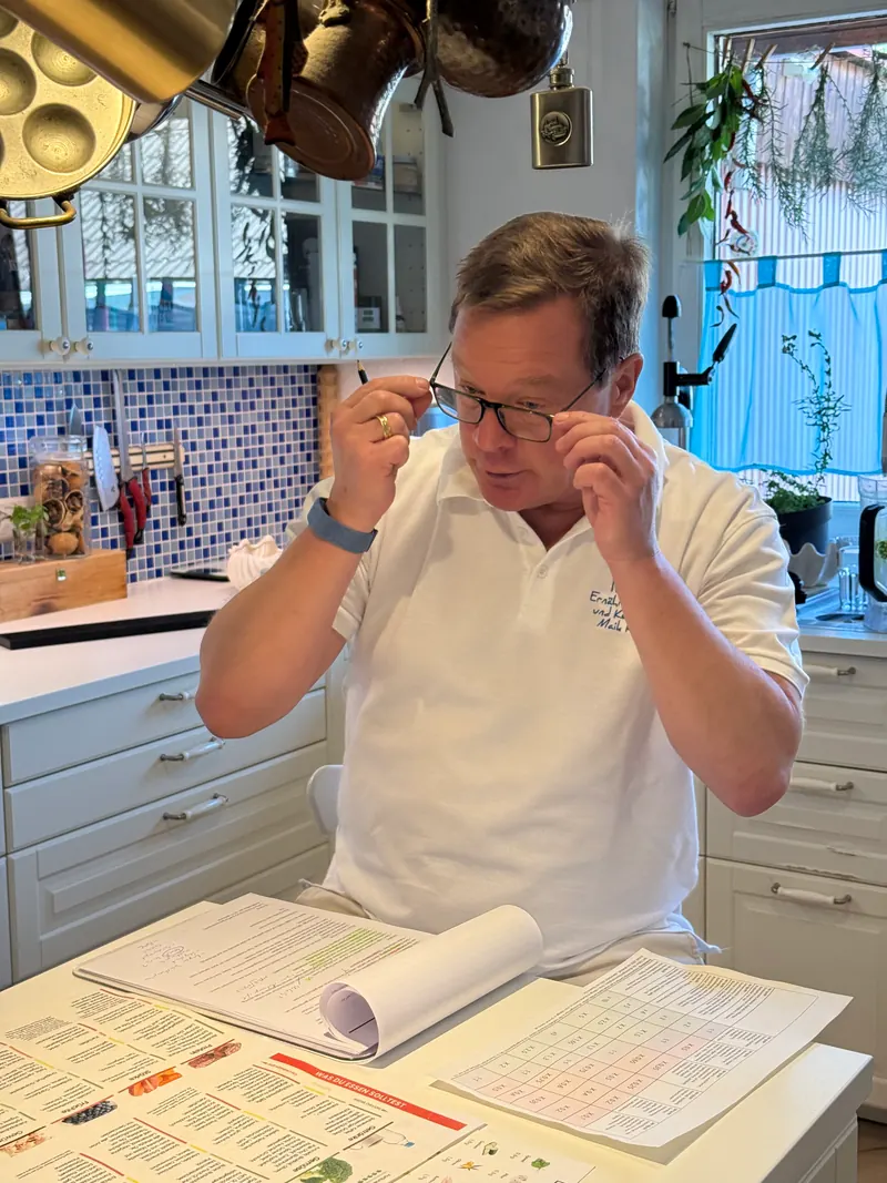 Maik Roemer rückt die Brille zurecht und liest in einem Ernährungsplan