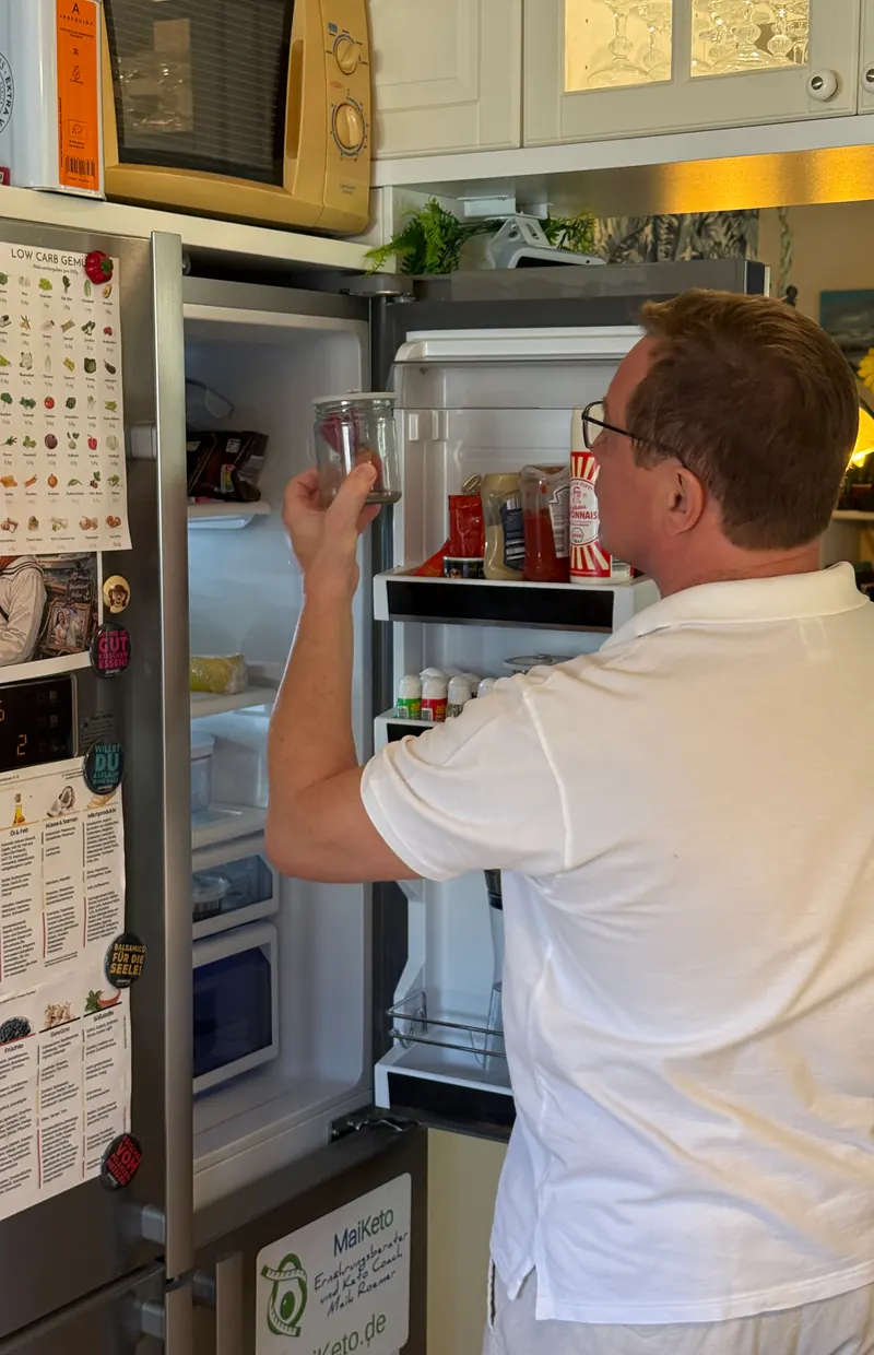 Maik Roemer prüft beim Kühlschrank-Check ein Glas aus dem Kühlschrank