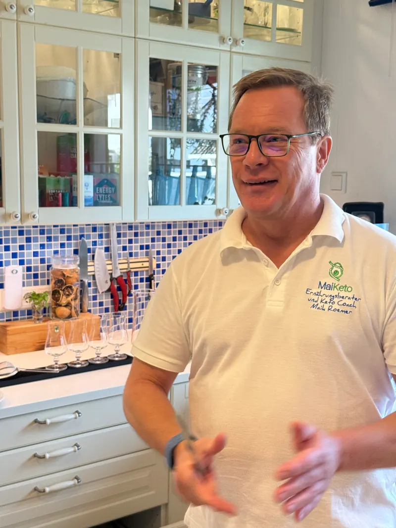 Maik Roemer erklärt mit offenen Händen und lächelt