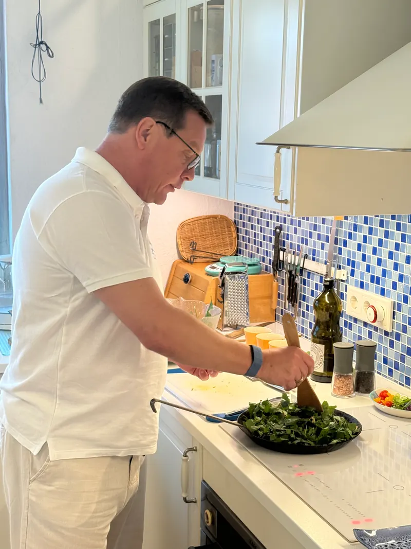 Maik Roemer rührt Kräuter in der Pfanne