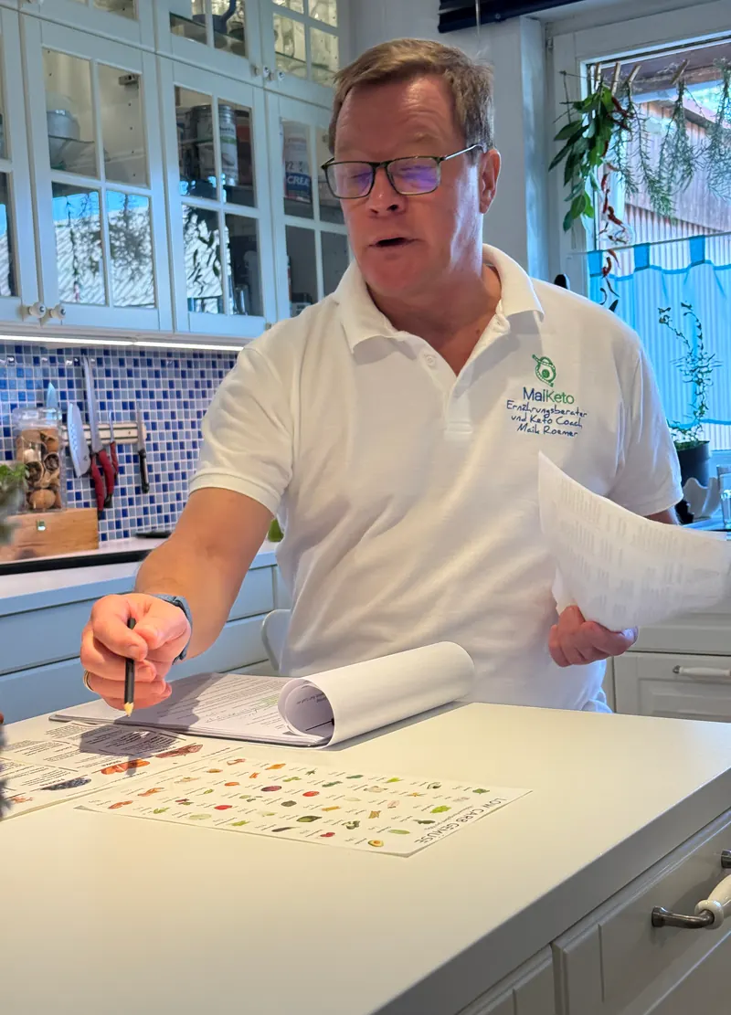 Maik Roemer arbeitet mit Stift und Unterlagen an einem Ernährungsplan