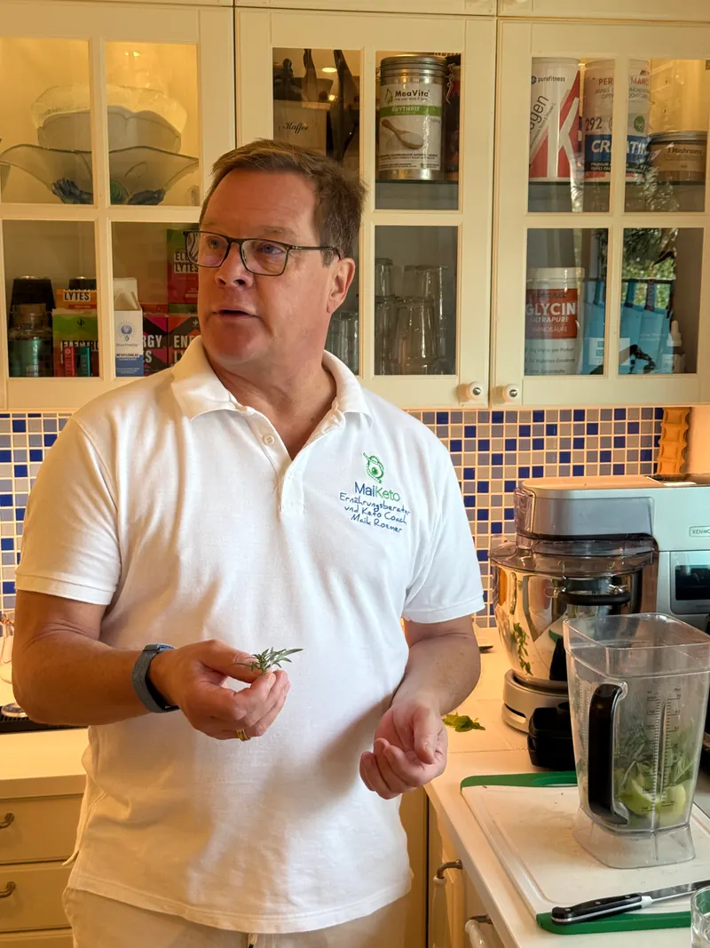 Maik Roemer erklärt mit einem Rosmarinzweig in der Hand